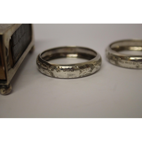 557 - A silver matchbox holder and a pair of silver napkin rings.