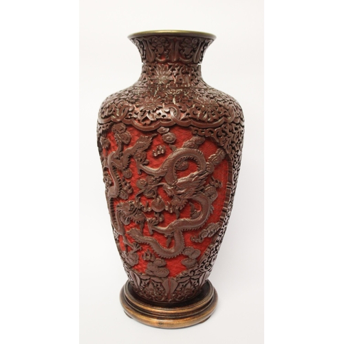 313 - A large cinnabar lacquer and blue enamel highly carved Chinese vase on a hardwood stand, 16