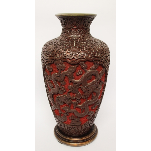 313 - A large cinnabar lacquer and blue enamel highly carved Chinese vase on a hardwood stand, 16