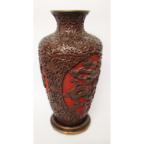 313 - A large cinnabar lacquer and blue enamel highly carved Chinese vase on a hardwood stand, 16