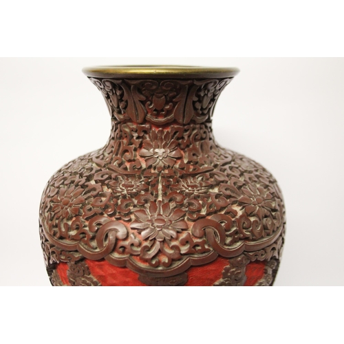 313 - A large cinnabar lacquer and blue enamel highly carved Chinese vase on a hardwood stand, 16