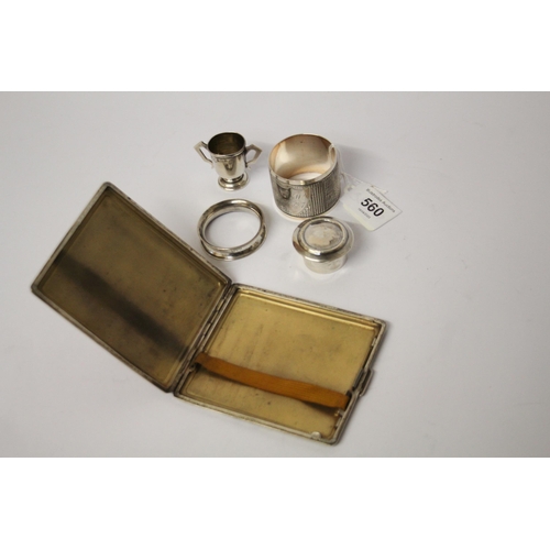 560 - An engine turned silver cigarette case, napkin rings and small silver trophy cup etc. 6 troy ounces