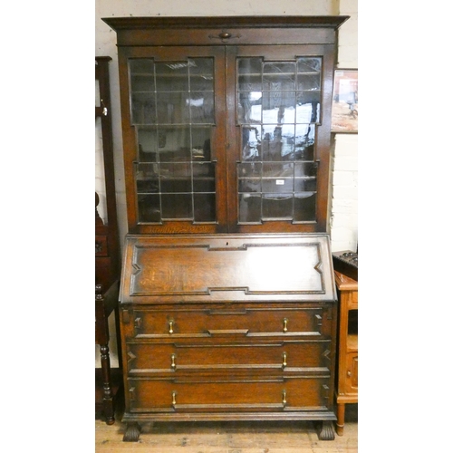 407 - A 1930's oak leaded glazed bureau bookcase with long drawers under, standing on carved feet, 3'6 wid... 