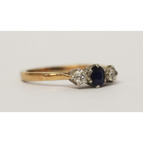 594 - A three stone sapphire and diamond ring, on 18ct yellow gold band. Ring size K