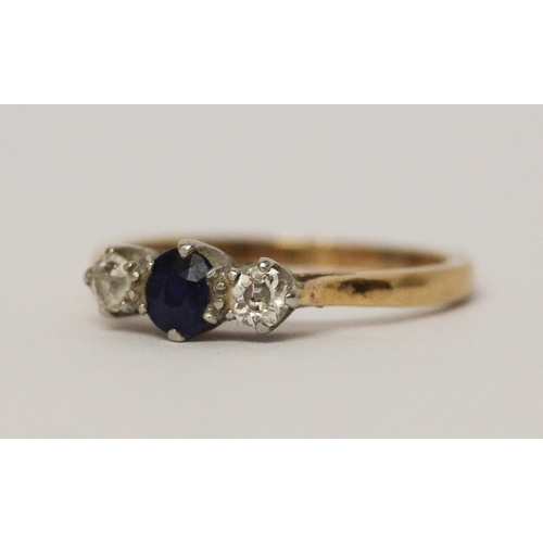 594 - A three stone sapphire and diamond ring, on 18ct yellow gold band. Ring size K