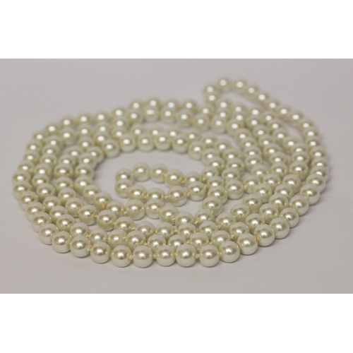 596 - A long row of uniform cultured pearls, individually knotted rope, 140 cms long approx