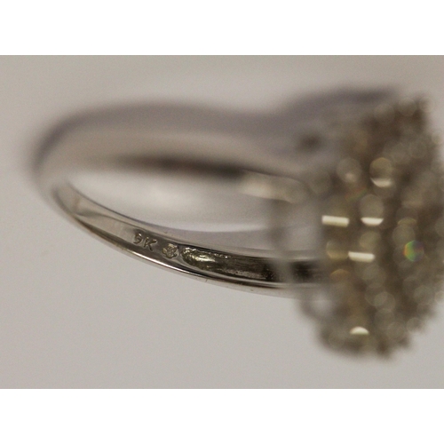 597 - A large modern circular diamond cluster ring, on 9ct white gold band. Ring size N