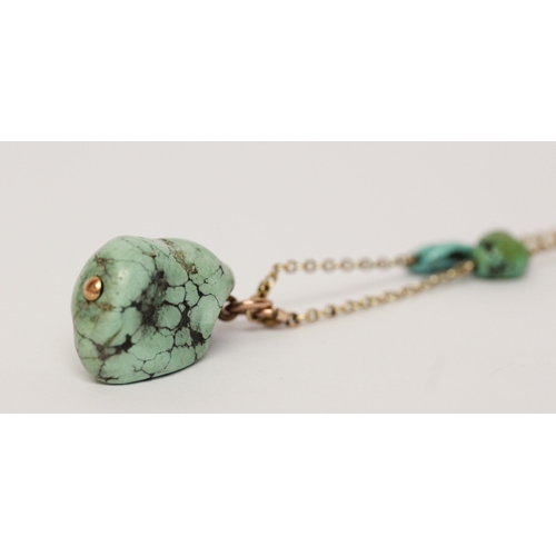 621 - A 1920's gold and turquoise nugget pendant necklace, approximately 65 cms long. Clasp marked '9ct'.