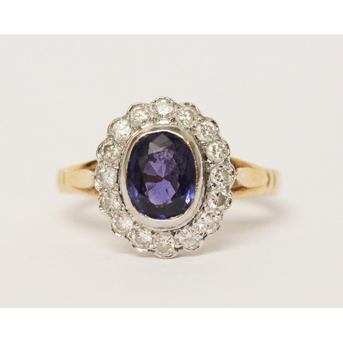 649 - A modern sapphire and diamond oval cluster ring, oval sapphire of good colour in rub over setting su... 