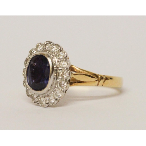 649 - A modern sapphire and diamond oval cluster ring, oval sapphire of good colour in rub over setting su... 