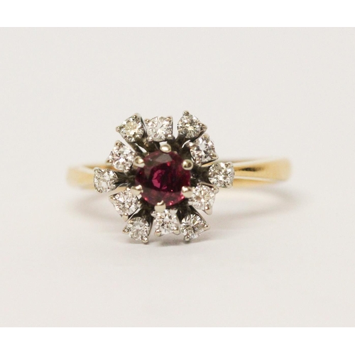 651 - A ruby and diamond cluster ring, in a circular design, on yellow 18ct gold band. Marked '18ct'. Ring... 