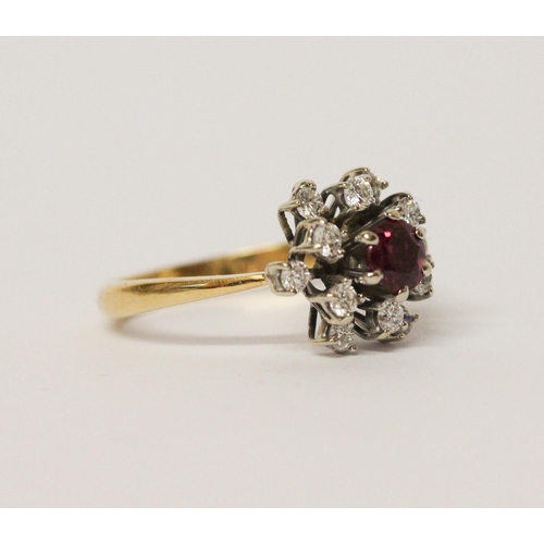 651 - A ruby and diamond cluster ring, in a circular design, on yellow 18ct gold band. Marked '18ct'. Ring... 