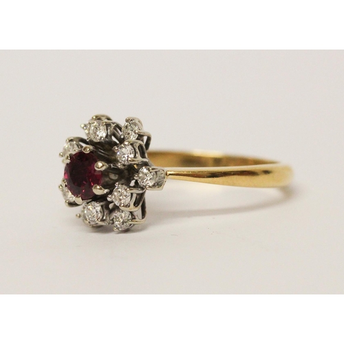 651 - A ruby and diamond cluster ring, in a circular design, on yellow 18ct gold band. Marked '18ct'. Ring... 