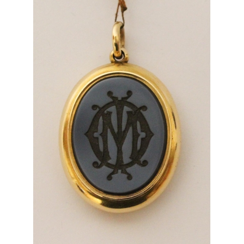 673 - A Victorian gold mourning locket, of oval form with intaglio hard stone panel to the front m, inside... 