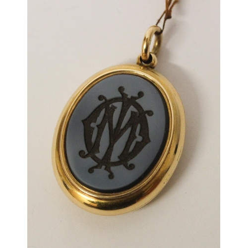 673 - A Victorian gold mourning locket, of oval form with intaglio hard stone panel to the front m, inside... 