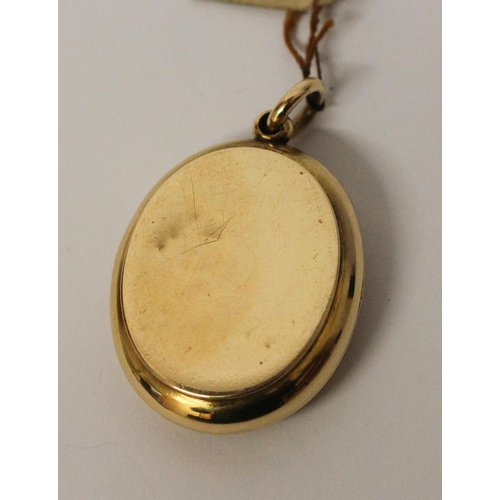 673 - A Victorian gold mourning locket, of oval form with intaglio hard stone panel to the front m, inside... 