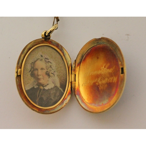 673 - A Victorian gold mourning locket, of oval form with intaglio hard stone panel to the front m, inside... 