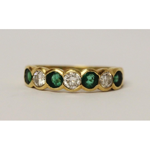 684 - An emerald and diamond half hoop ring, set circular brilliant cut diamonds alternating with emeralds... 