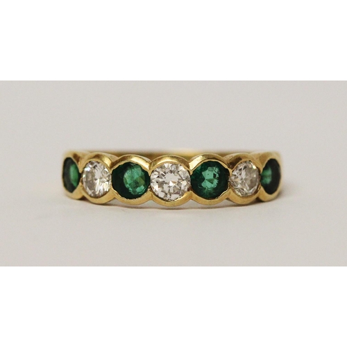 684 - An emerald and diamond half hoop ring, set circular brilliant cut diamonds alternating with emeralds... 