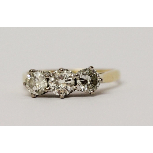 724 - A three stone diamond ring, in claw setting on 18ct hallmarked yellow gold band, total diamond weigh... 