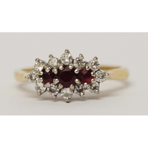 728 - A three stone ruby and diamond cluster ring, on 18ct yellow gold band. Ring size N, weight 3.5g