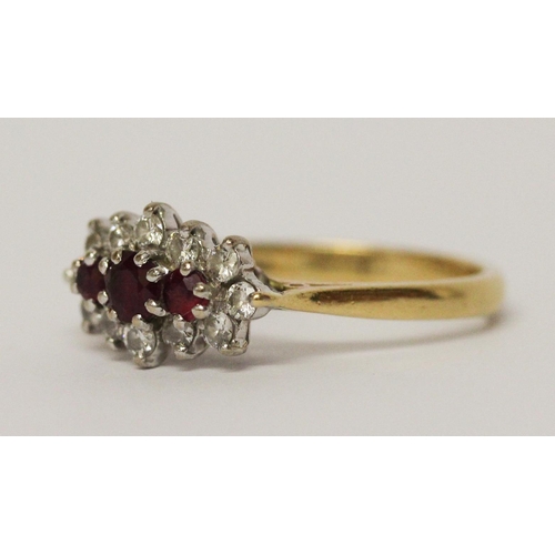 728 - A three stone ruby and diamond cluster ring, on 18ct yellow gold band. Ring size N, weight 3.5g