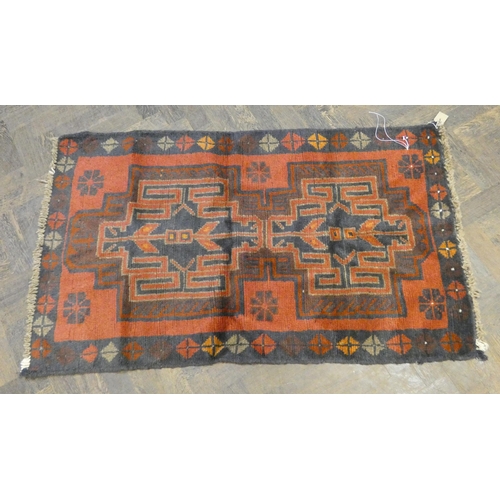 174 - A red and patterned Afghan wool pile rug, 4'9 x 2'10