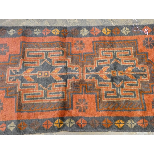 174 - A red and patterned Afghan wool pile rug, 4'9 x 2'10