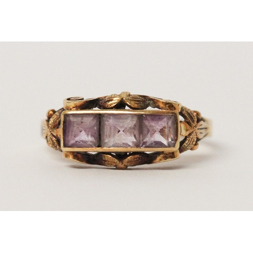 538 - A three stone amethyst ring, in carved 14ct yellow gold setting, shank marked 585. Ring size P