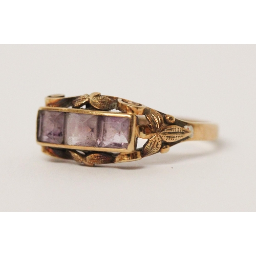 538 - A three stone amethyst ring, in carved 14ct yellow gold setting, shank marked 585. Ring size P