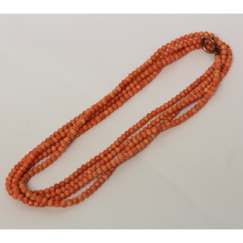 625 - An Art Deco long row of uniform coral beads, approximately 180 cms long