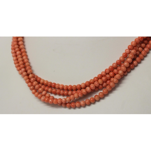 625 - An Art Deco long row of uniform coral beads, approximately 180 cms long