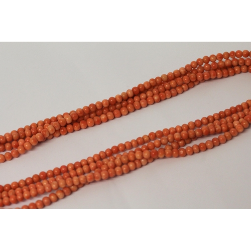 625 - An Art Deco long row of uniform coral beads, approximately 180 cms long