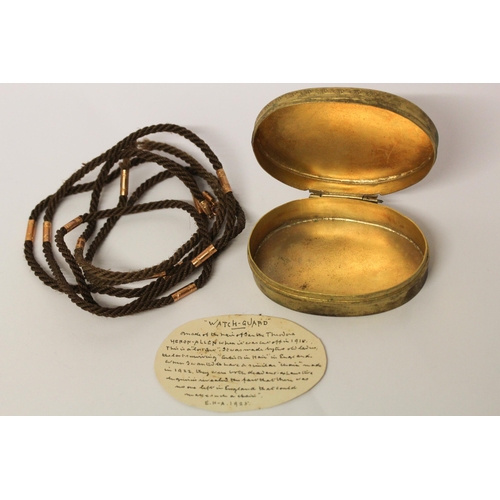 690 - A woven hair watch long guard chain, with gold mounts. Kept within gilt metal oval box, with hand wr... 