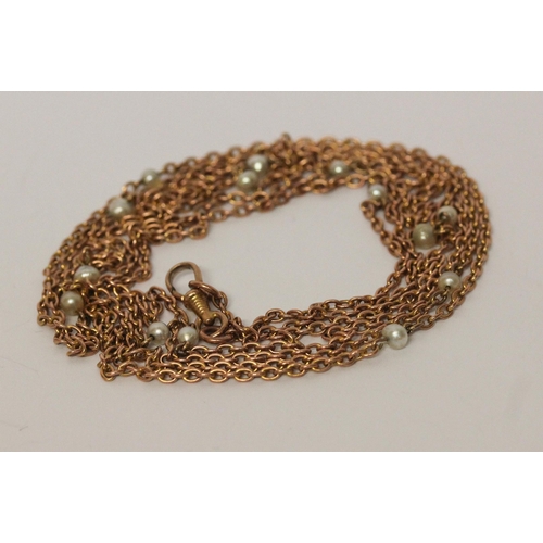 694 - A Victorian rose gold long guard chain, set with freshwater pearls, marked 9c to clasp, 150 cms long... 