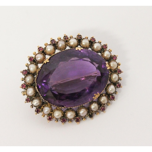 695 - A Victorian amethyst, ruby and pearl oval brooch, the large oval amethyst of good colour, surrounded... 