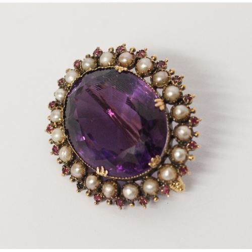 695 - A Victorian amethyst, ruby and pearl oval brooch, the large oval amethyst of good colour, surrounded... 