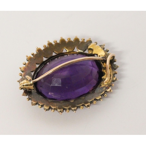 695 - A Victorian amethyst, ruby and pearl oval brooch, the large oval amethyst of good colour, surrounded... 