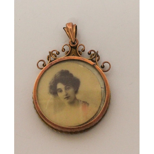 701 - An Edwardian mourning locket, of circular form with glazed panels to each side, frame set with seed ... 