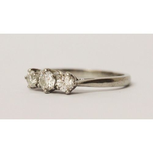 718 - A platinum and diamond three stone ring, with three brilliant cut graduated diamonds in claw setting... 