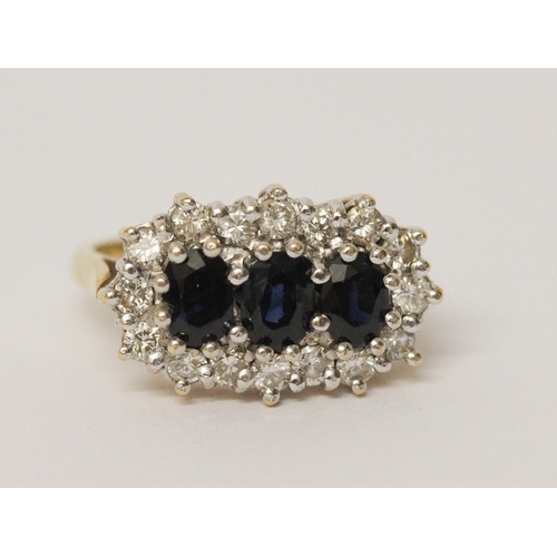 719 - A three stone sapphire and diamond ring, the three oval sapphires surrounded by a cluster of brillia... 