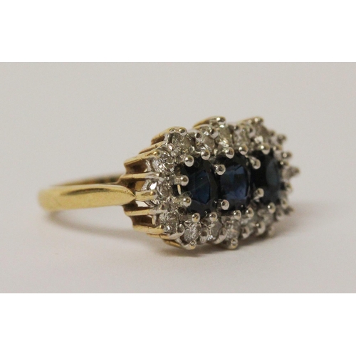 719 - A three stone sapphire and diamond ring, the three oval sapphires surrounded by a cluster of brillia... 