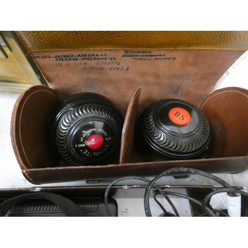 884 - A brown leather carrying case with a set of four balls in and brown leather case with two bowling ba... 