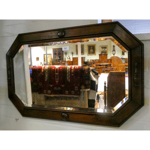 257 - A bevelled wall mirror in oak frame