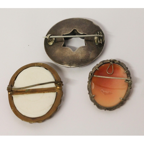 572 - A Scottish hardstone circular brooch in silver mount and two framed cameo brooches