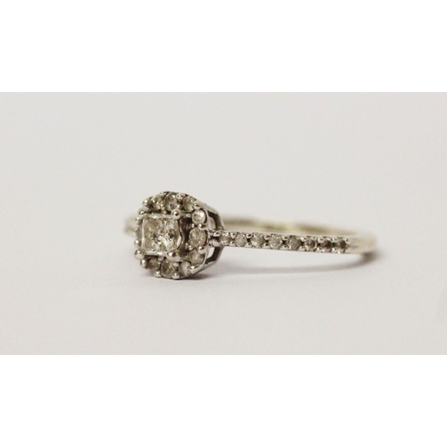 571 - A modern diamond cluster ring, on diamond set shoulders in 9ct white gold. Hallmarked, ring size M