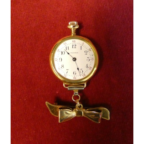 569 - Edwardian ladies fob watch or nurses watch by Waltham, gold plated on plated ribbon bow brooch faste... 