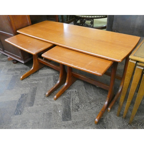 122 - A nest of three teak coffee tables comprising one long and two smaller under