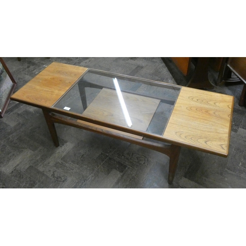 173 - A long teak coffee table with inset glass in the centre