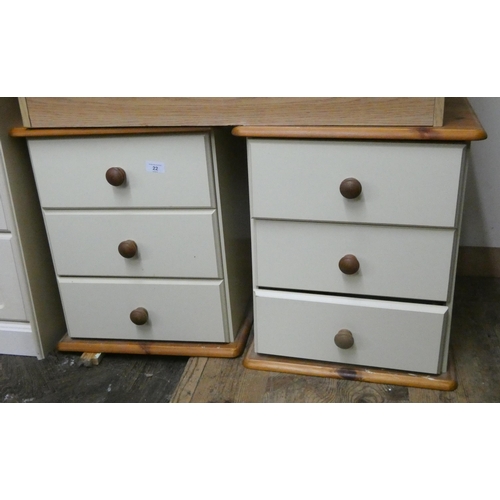 22 - A pair of cream and light wood bedside chests each fitted three drawers